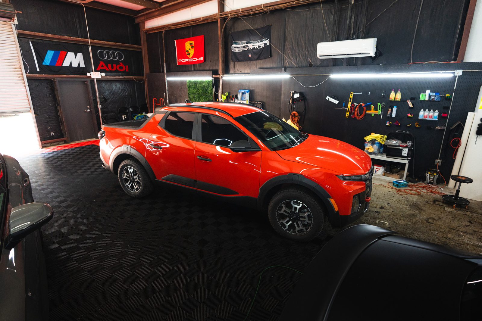 A red truck under the hex lights in the UltraHI Tintz shop